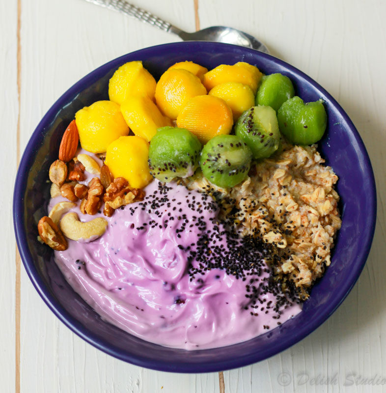 closeup view of overnight oats with blueberry yoghurt in a blue bowl