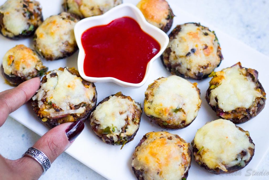 A bite of cheese stuffed mushroom as a party appetiser