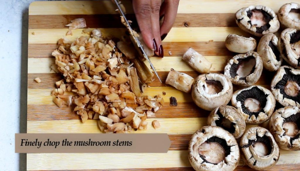 Finely chop mushroom stems for making cheese stuffed mushrooms