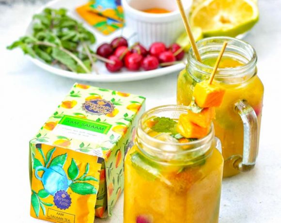 Aam Salaam mango iced tea mocktail in two mason jars with fresh fruits and mangoes