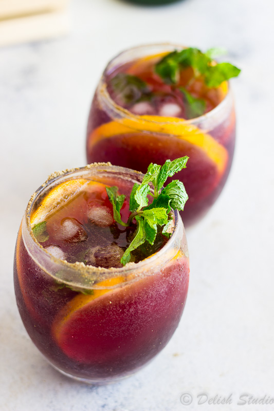 Close up image of 2 glasses of Jaljeera mixed with the goodness of Red wine Sangria is what makes up this tangy, boozy, fizzy refreshing summer cocktail! Super easy to make this is recipe gives an Indian twist to classic Red wine Sangria!